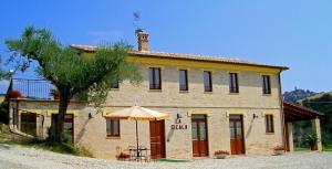 a building with an umbrella in front of it at Agriturismo La Cicala in Carassai