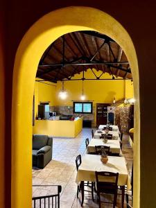 une salle à manger avec des tables et un mur jaune dans l'établissement I Gelsomini, à Marinella di Selinunte