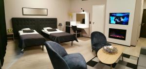 KankaanpääにあるSport Hotel Kantriのリビングルーム(ベッド2台、暖炉付)