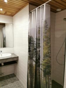 a bathroom with a shower curtain and a sink at Sport Hotel Kantri in Kankaanpää