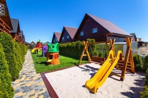 a playground with a slide in a yard at Domki Kaper Karwia in Karwia
