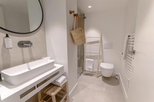 a white bathroom with a sink and a toilet at Les Suites de Collioure in Collioure