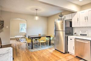 a kitchen with a table and a stainless steel refrigerator at Updated Lexington Apartment Near Downtown, UK! in Lexington