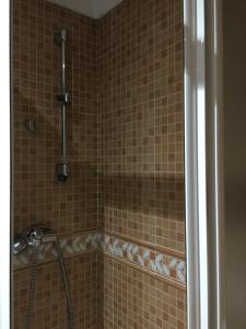 a shower in a bathroom with brown tile at Hostal Ana in Alhama de Granada