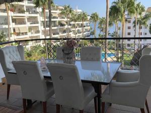 a table and chairs on a balcony with a view of a building at Mi Capricho Apartment with Sea Views and Gardens in La Cala de Mijas