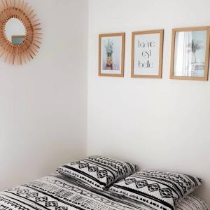 a shelf with pillows and a mirror on a wall at STUDIO ENTRE PLAGE ET PORT in Les Sables-d'Olonne