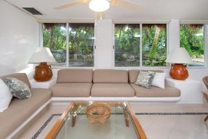 a living room with a couch and a glass table at Las Villas Akumal in Akumal