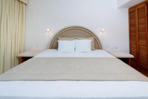a bedroom with a large white bed with two pillows at Las Villas Akumal in Akumal