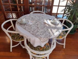 uma mesa branca com cadeiras e uma toalha de mesa branca em Hotel Fita Azul em Ilhabela