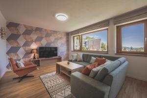 een woonkamer met een bank en een tv bij Apartman Central Ski & Bike in Janske Lazne