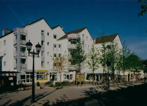 een groot wit gebouw met bomen ervoor bij Innovative 2-Zimmer-Ferienwohnung am Kurpark in Bad Kreuznach