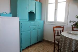 um armário azul num quarto com uma mesa em La Maison du Marin em Mesariá