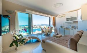 - un salon avec un canapé et de grandes fenêtres dans l'établissement Apartments Dilberovic, à Dubrovnik
