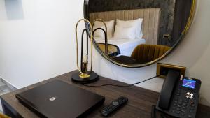 um quarto com uma secretária com um computador portátil e um espelho em Hotel Pasha em Mostar