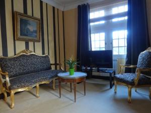 a living room with a couch and chairs and a table at Hostellerie Restaurant Les Gorges de l'Aveyron in Bruniquel