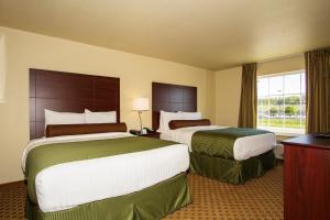 a hotel room with two beds and a window at Cobblestone Inn & Suites - Corry in Corry
