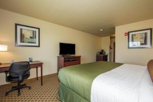 a hotel room with a bed and a desk and a television at Cobblestone Inn & Suites - Corry in Corry