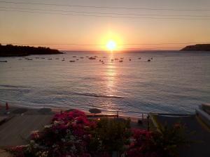 a sunset over the ocean with boats in the water at Buganvilla Sea View apts in Agia Pelagia