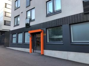 una puerta naranja en el lateral de un edificio en Patria apartments, en Lahti
