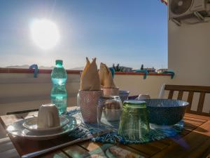 a table with plates and bottles on top of it at B&B La Quercia Budoni, Tanaunella in Budoni
