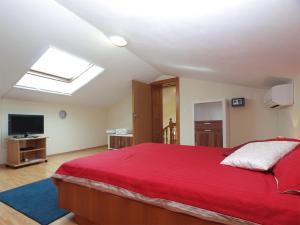 a bedroom with a red bed and a television at House Peroj 705 in Peroj