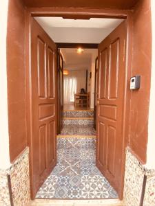 an empty hallway with doors and a tile floor at Casa Las Gardenias in Setenil