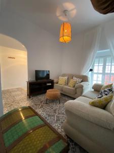 a living room with a couch and a tv at Casa Las Gardenias in Setenil