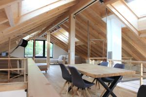una sala da pranzo con tavolo e sedie in legno di INVITA Natur-Chalets Penthouse a Bad Dürrheim