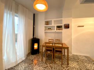 a dining room with a table and a wood stove at Casa Las Gardenias in Setenil