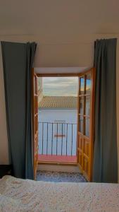 sypialnia z drzwiami wychodzącymi na balkon w obiekcie Casa Las Gardenias w mieście Setenil