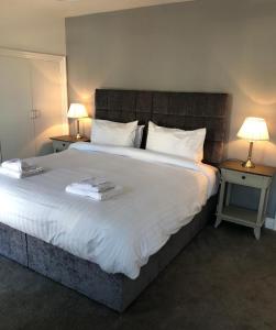 1 dormitorio con 1 cama blanca grande y 2 mesas en Queen Street Apartments, en Enniskillen