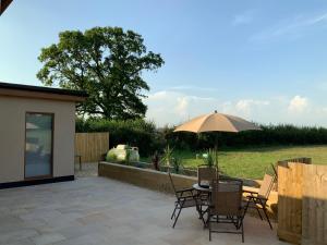 a patio with a table and an umbrella at Mystique Barn in Bristol