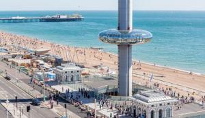 a beach with a crowd of people and the ocean at The Beach Hotel in Brighton & Hove