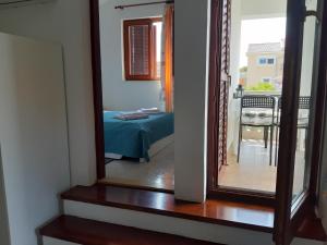 specchio in una stanza con letto e tavolo di Apartmani Pilon a Ždrelac