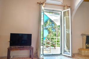 un soggiorno con porta che conduce a un balcone di Villa Mikalef a Perama