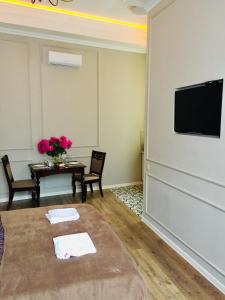 a living room with a table and a flat screen tv at Апартаменти Кобилянська 9 in Chernivtsi