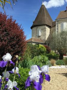 een tuin met paarse en witte bloemen voor een huis bij Gîtes de la Porte Saint Martin in Châteauroux