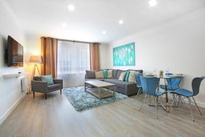 a living room with a couch and a table and chairs at Vkm Apartments in Glasgow