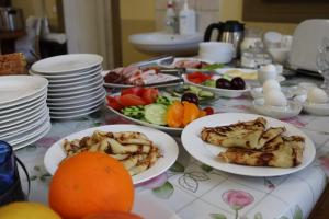 a table with plates of food and fruit on it at Hostel Lõuna in Pärnu