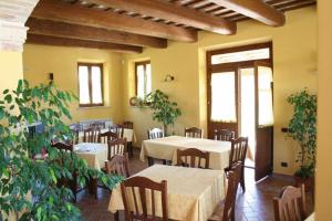 un comedor con mesas, sillas y plantas en Agriturismo La Cicala, en Carassai