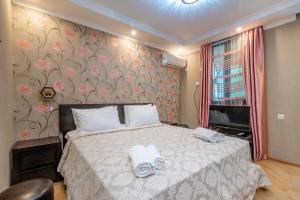 a bedroom with a bed with white towels on it at Borjomi Villa Roma in Borjomi