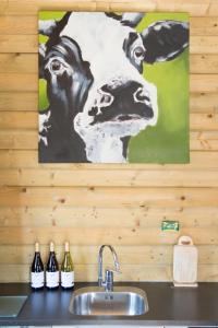 una pintura de un caballo en la pared sobre un fregadero de cocina en 6 persoons vakantiehuis met sauna, dichtbij zee, en Sint Annaland