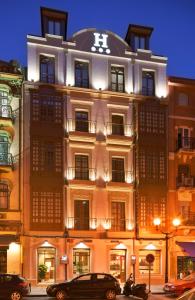 ein Gebäude mit einem Kreuz darüber in der Unterkunft Hotel Marqués, Blue Hoteles in Gijón