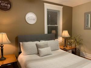 a bedroom with a bed with two lamps and a clock at Historical Neighborhood Home in New Rochelle