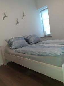 a bed with two pillows on it in a room at Echt Ostfriesenhus in Norden