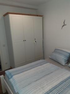a bedroom with a bed and a white cabinet at Echt Ostfriesenhus in Norden