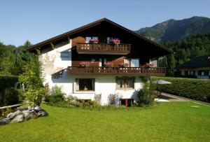 a house with a balcony with flowers on it at Das Schönanger Ferienwohnungen in Grainau