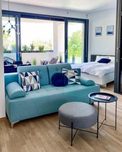 ein Wohnzimmer mit einem blauen Sofa und einem Bett in der Unterkunft Seaview Apt Koper 1 in Koper