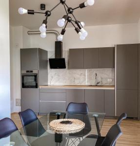 a kitchen with a glass table and blue chairs at Seaview Apt Koper 1 in Koper