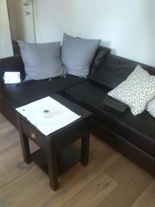 a black couch with two pillows and a table at Echt Ostfriesenhus in Norden